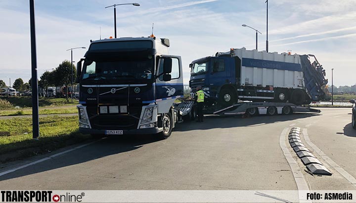 Vrachtwagen met vuilniswagen rijdt zich vast op rotonde in Veghel [+foto]