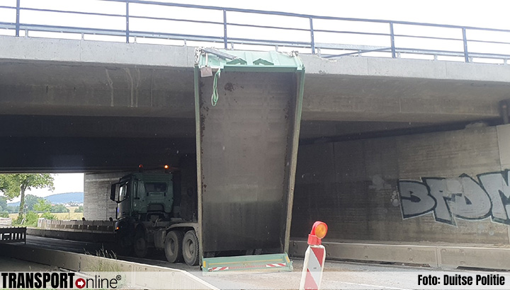 Vrachtwagenchauffeur blijft met bak achter viaduct hangen [+foto]