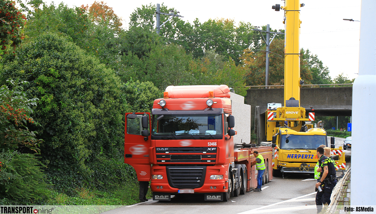 Vrachtwagen geladen met betonplaten vast onder spoorbrug in Weert [+foto's]